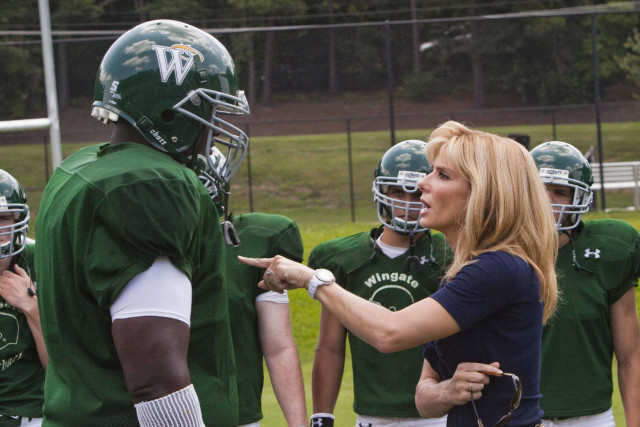 a woman talking to a football player on the field