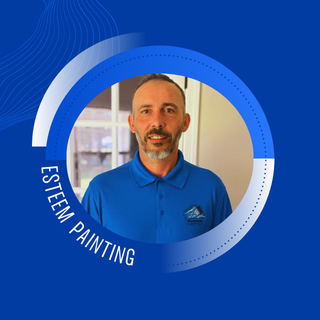 Man in blue polo shirt representing Esteem Painting, showcasing professional residential painting services and craftsmanship.