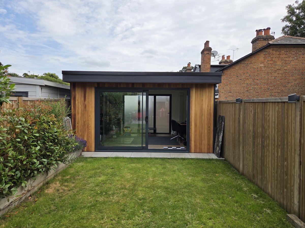 Modern cedar-clad garden office with black sliding doors in Weybridge, Surrey
